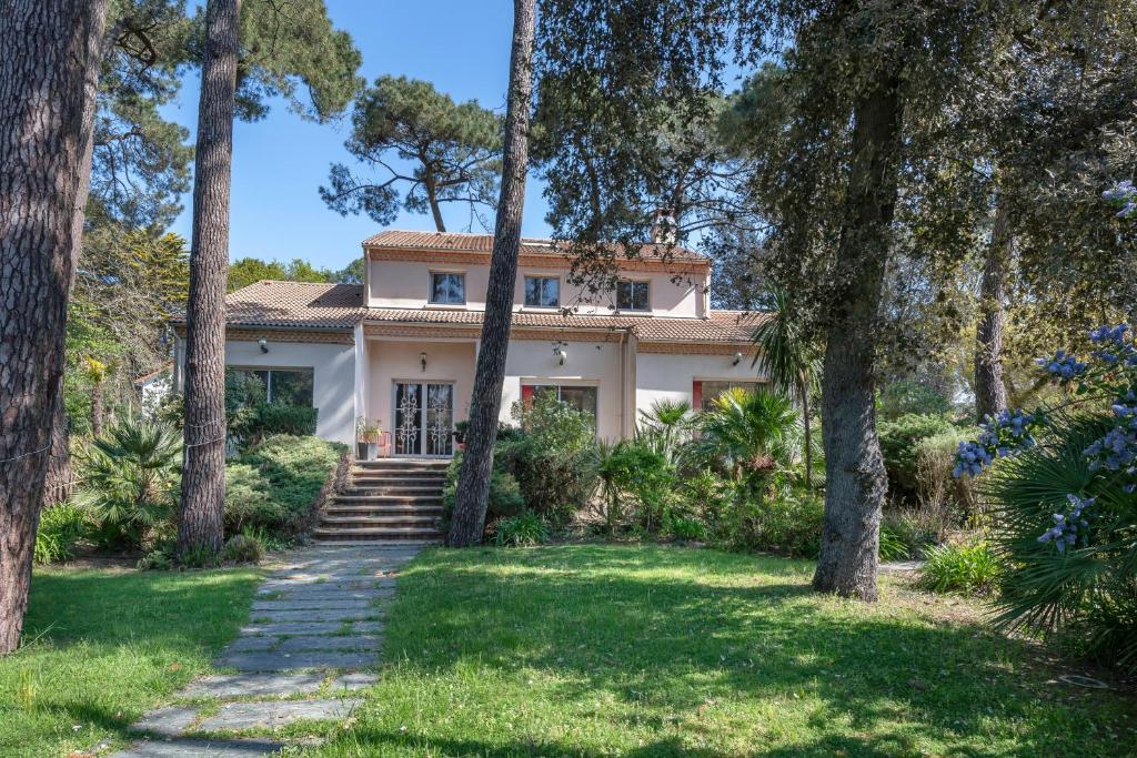 una casa con alberi davanti di Villa avec jacuzzi - 15 pers. à 350m de la plage a Saint-Brévin-les-Pins