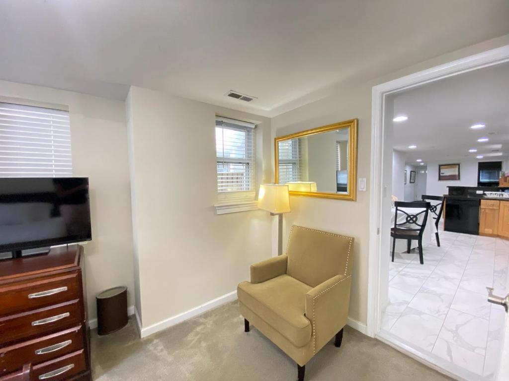 ein Wohnzimmer mit einem TV und einem Stuhl in der Unterkunft Lovely Remodeled 2bdrm Basement Home in Washington