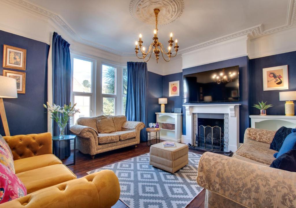伊爾弗勒科姆的住宿－Brywill House，客厅设有蓝色的墙壁和吊灯。