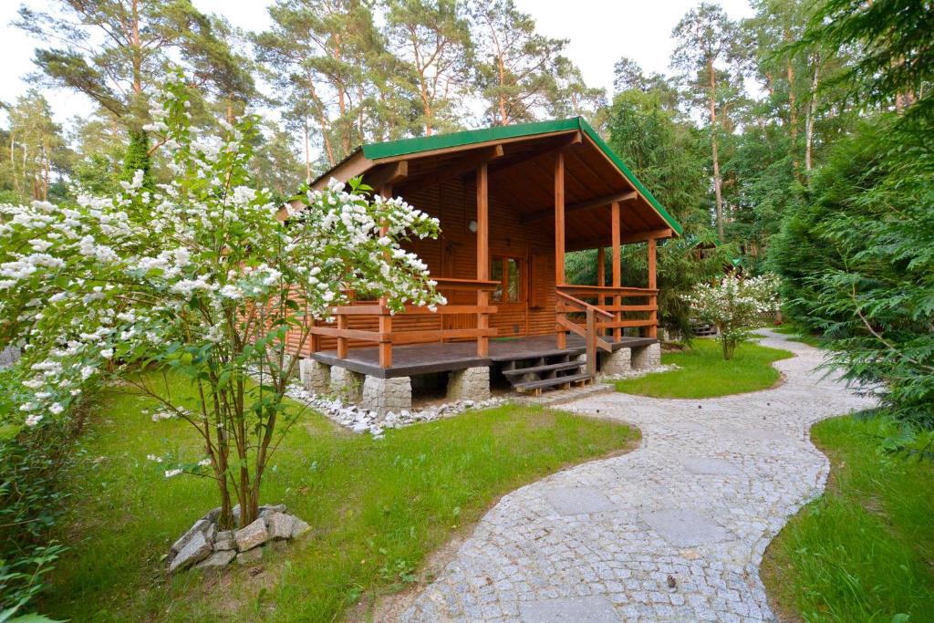 uma cabana de madeira no meio de um jardim em Ośrodek Wypoczynkowy "Puszczyk" Wolnostojące Domki z Bali em Sieraków