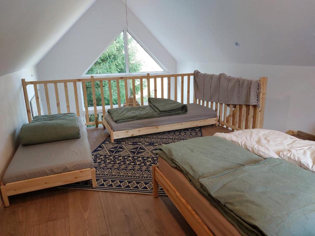 2 łóżka i krzesło w pokoju z balkonem w obiekcie Poczciwy Bies w mieście Myczków
