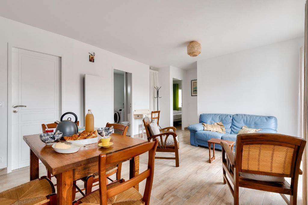 een woonkamer met een tafel en een blauwe bank bij Detente et evasion aux Sables dOlonnes in Les Sables-dʼOlonne
