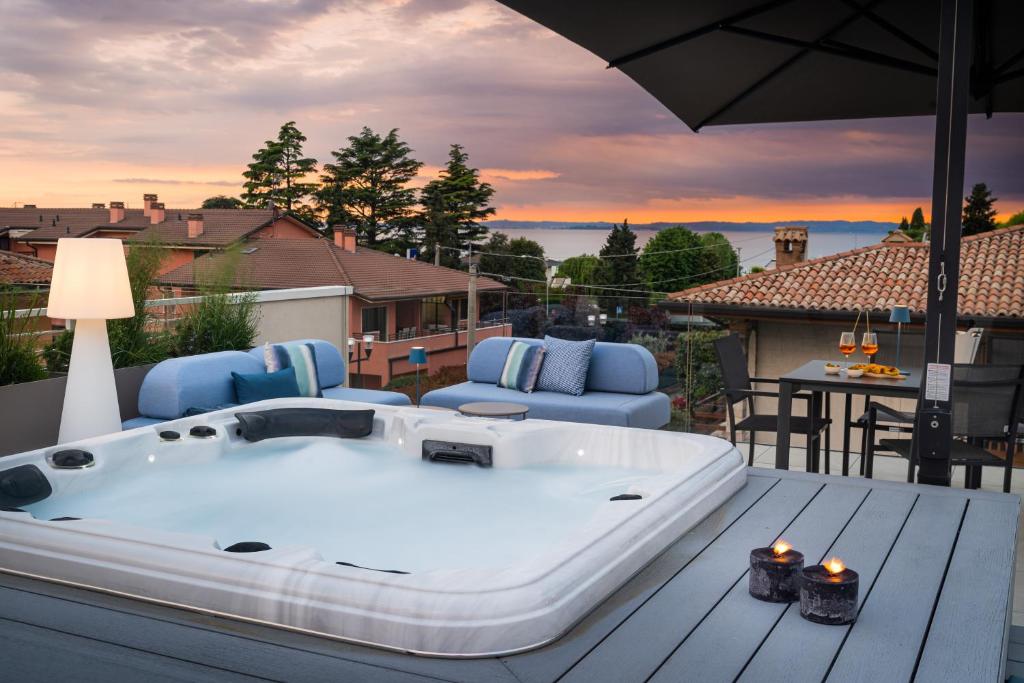 a bath tub sitting on a deck with an umbrella at Indigo Eco Apartments in Bardolino