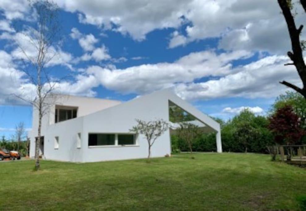 een wit huis met een groene tuin bij BASOANGYM Villa con jardin y bosque centenario in Laukiz