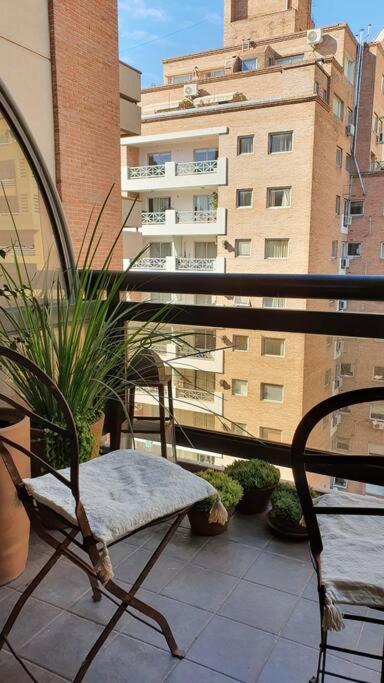 een stoel op een balkon met een gebouw bij Departamento en Nueva Cordoba in Cordoba