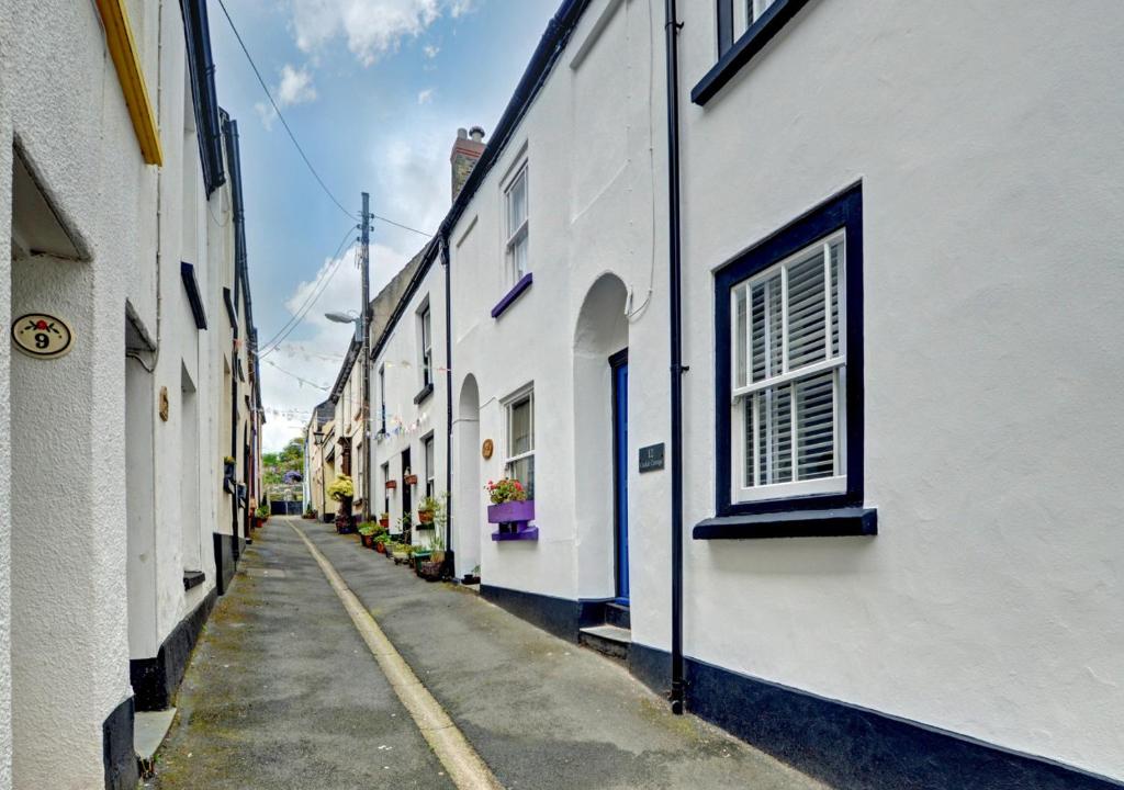 an alley with white buildings and a window at Cockle Cottage in Appledore