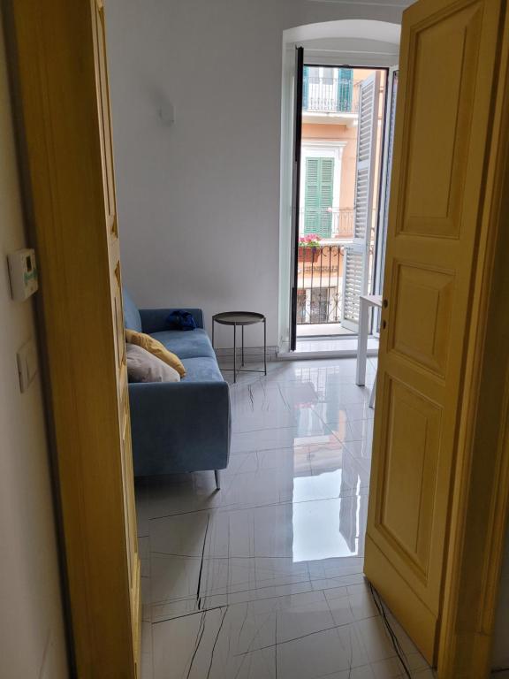 an open door to a living room with a blue couch at La finestra sul corso in Ortona