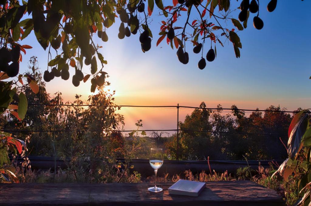 a glass of wine on a table with the sunset in the background at La casa de La Cartita in Puntagorda