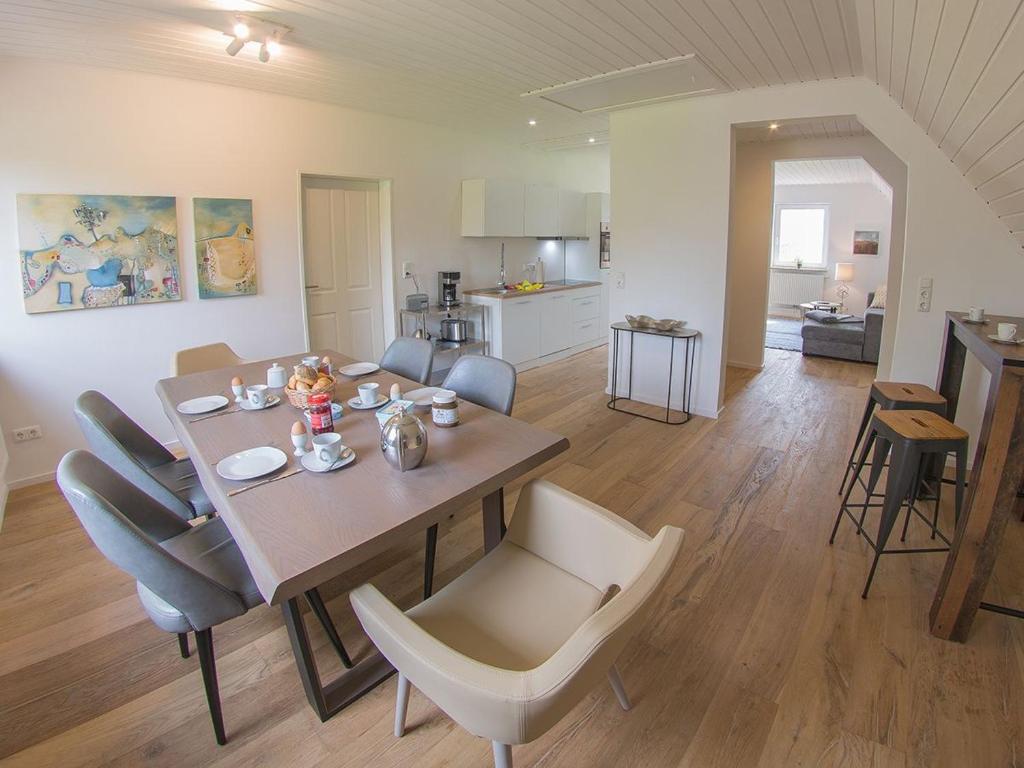 a dining table and chairs in a living room at Ferienwohnung Fresenhuus 3, FeWo Vermittlung Nordsee in Dangast
