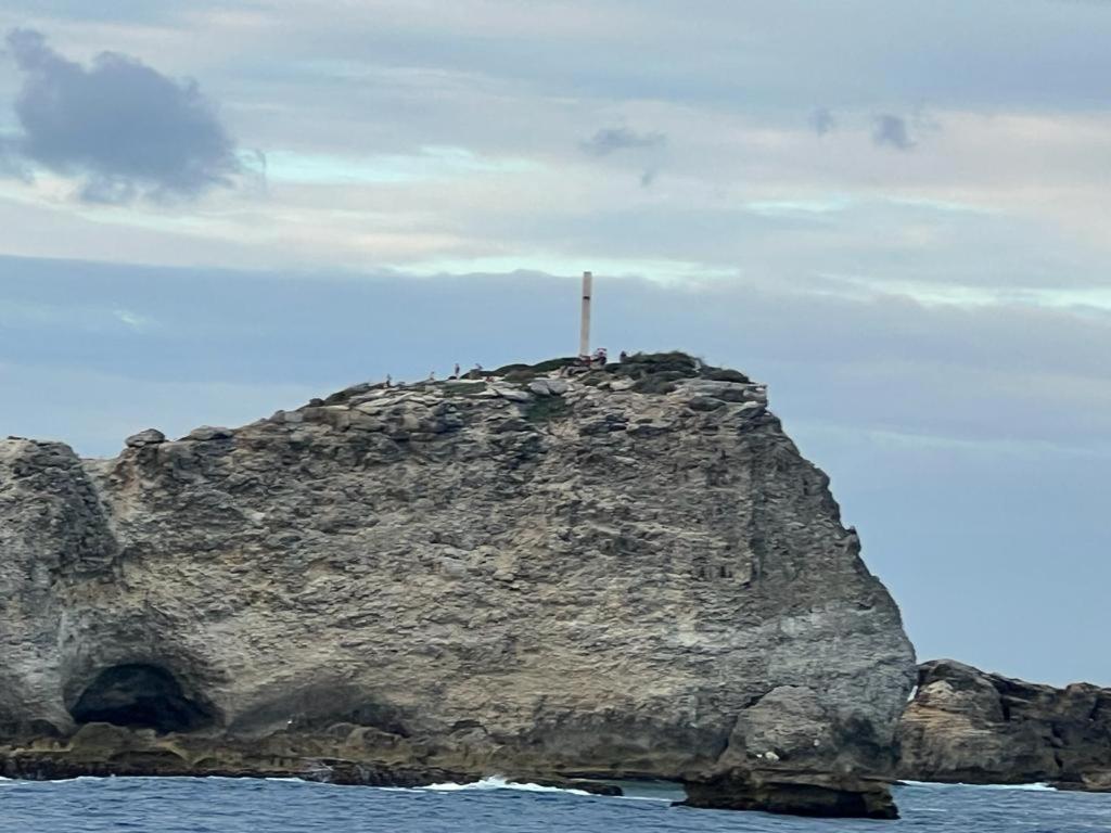 a cross on top of a rock in the water at Yeux D&#39;azur in Le Souffleur