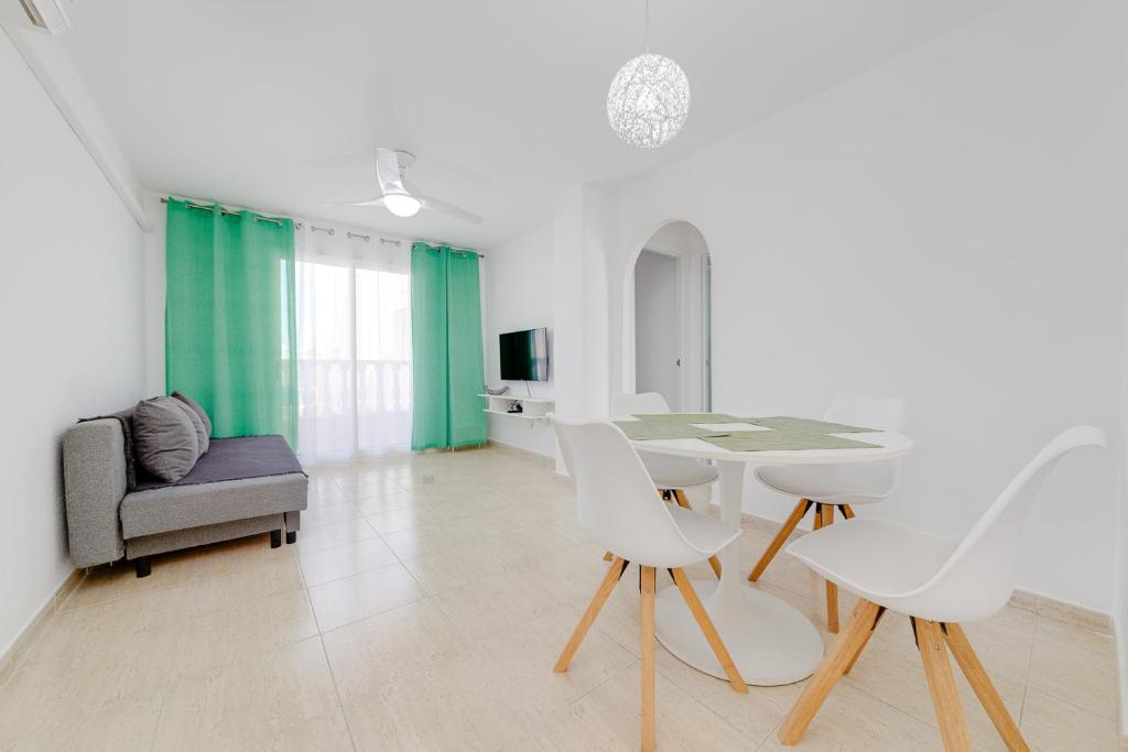 sala de estar con mesa, sillas y sofá en Casa Godisa, en Torrevieja