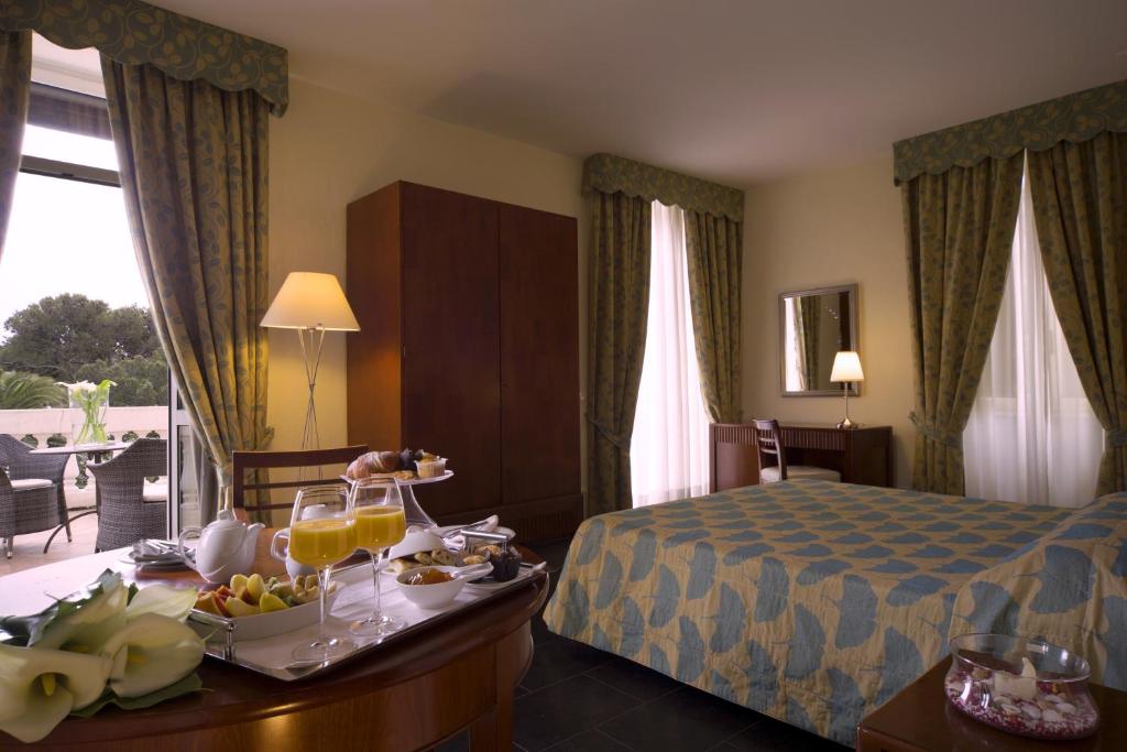 Habitación de hotel con cama y bandeja de comida en Villa Imperiale Hotel, en Spotorno