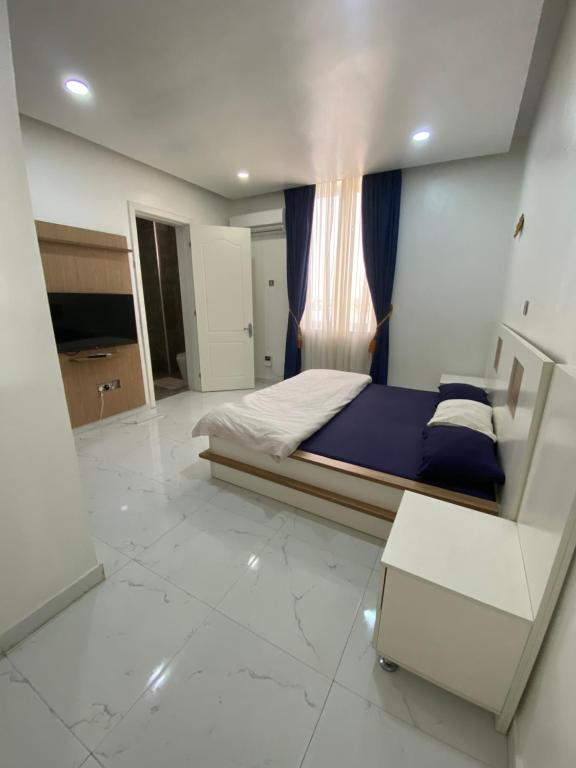 a bedroom with a bed and a window in it at Jivil Shortlets in Lagos