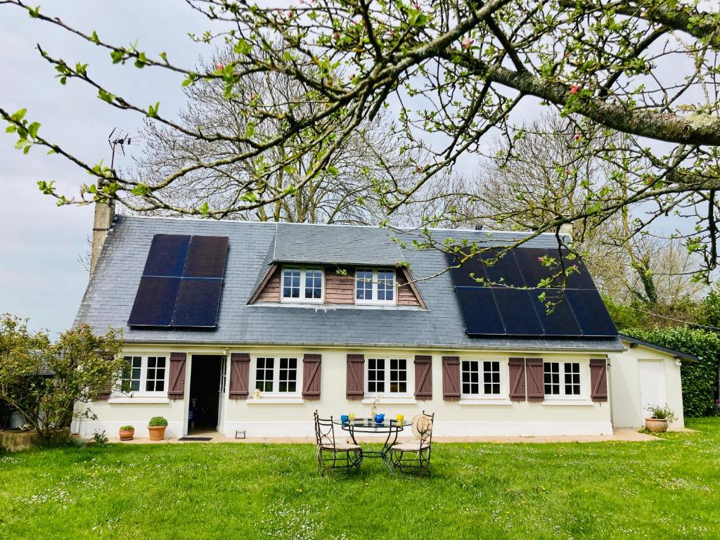 ein Haus mit Sonnenkollektoren auf dem Dach in der Unterkunft Les Forrières Maison de Campagne in Thil-Manneville