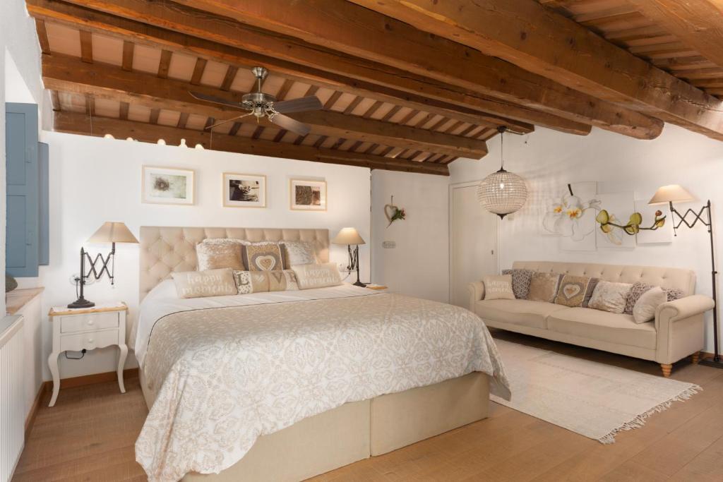 a bedroom with a large bed and a couch at Can Font de Muntanya Turisme Rural in Cruïlles