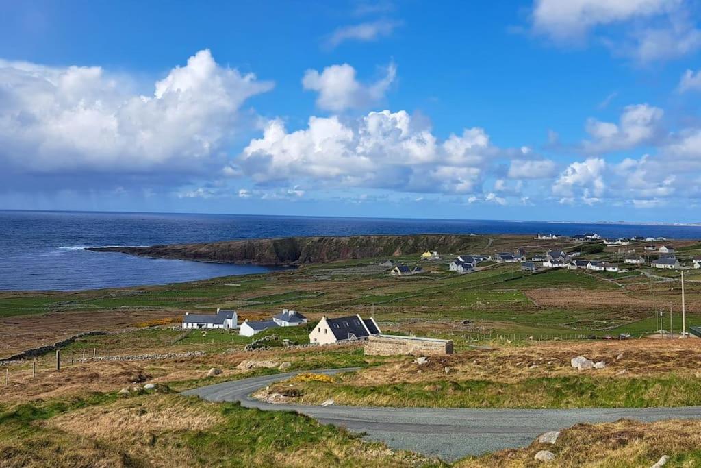 a small town on a hill near the ocean at The Ocean Lodge in Bunbeg