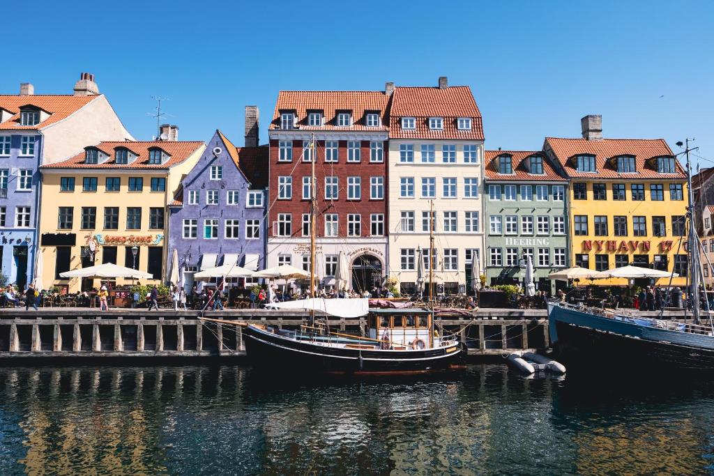 a group of boats docked in a river with buildings at Hotel Nyhavn63 in Copenhagen