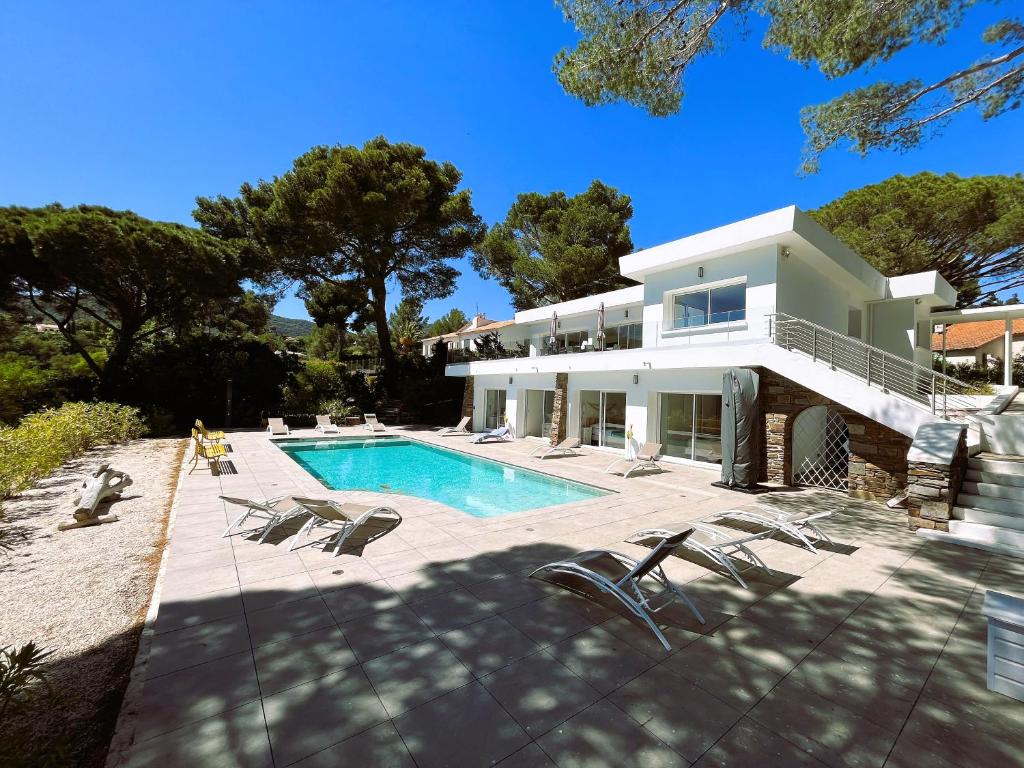 uma grande casa branca com piscina em Villa 6 Chambres, Piscine, vue Mer, à Proximité de la Plage , Cavalaire-sur-mer em Cavalaire-sur-Mer
