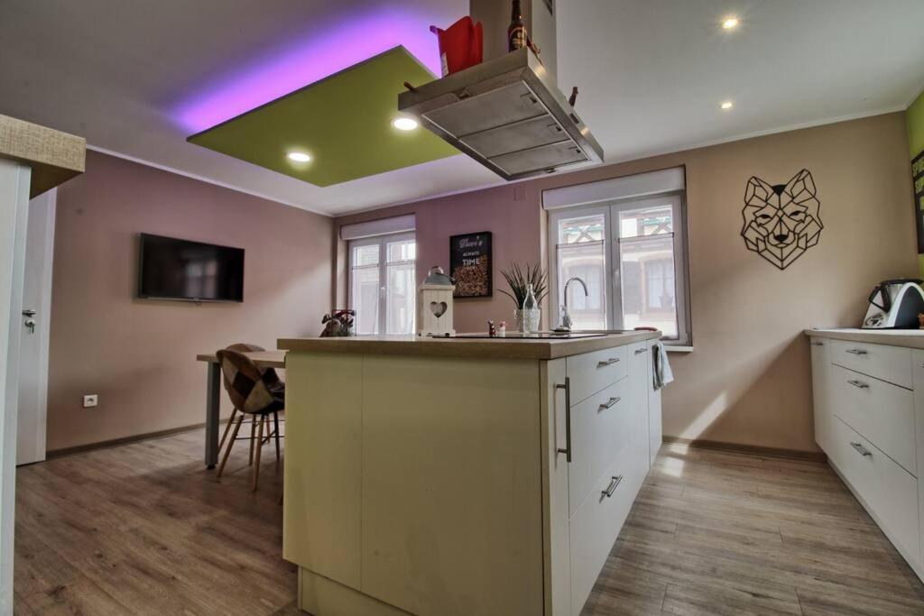 una cocina con una isla en medio de una habitación en Aux grains de raisin - 6 personnes - cour privée, en Scherwiller