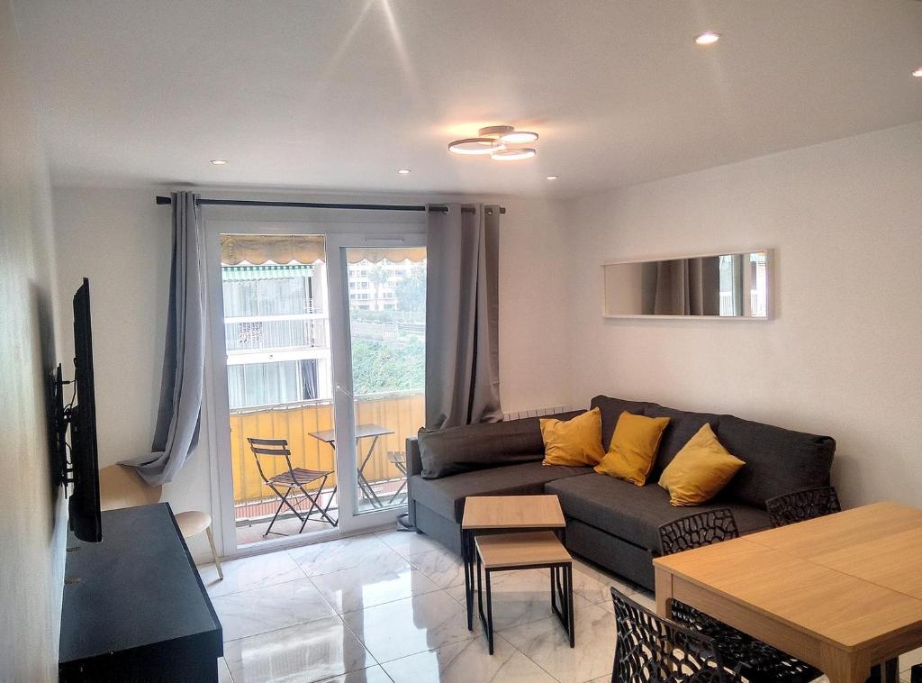 a living room with a couch and a table at Résidence le Serra A2 in Juan-les-Pins