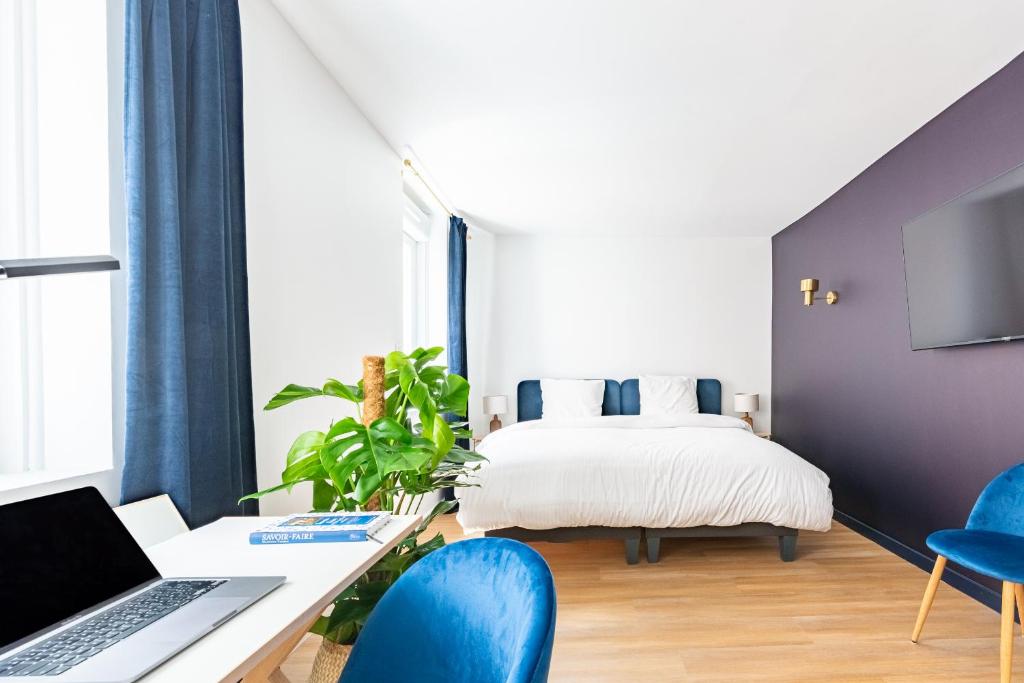 sypialnia z łóżkiem i biurkiem z laptopem w obiekcie Calme & Chic bleu - Proche gare et centre w mieście Dijon