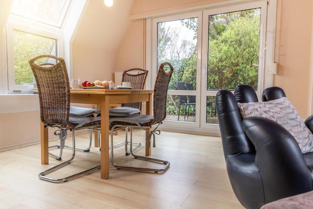 a dining room with a table and chairs and windows at 50156... in Harlesiel
