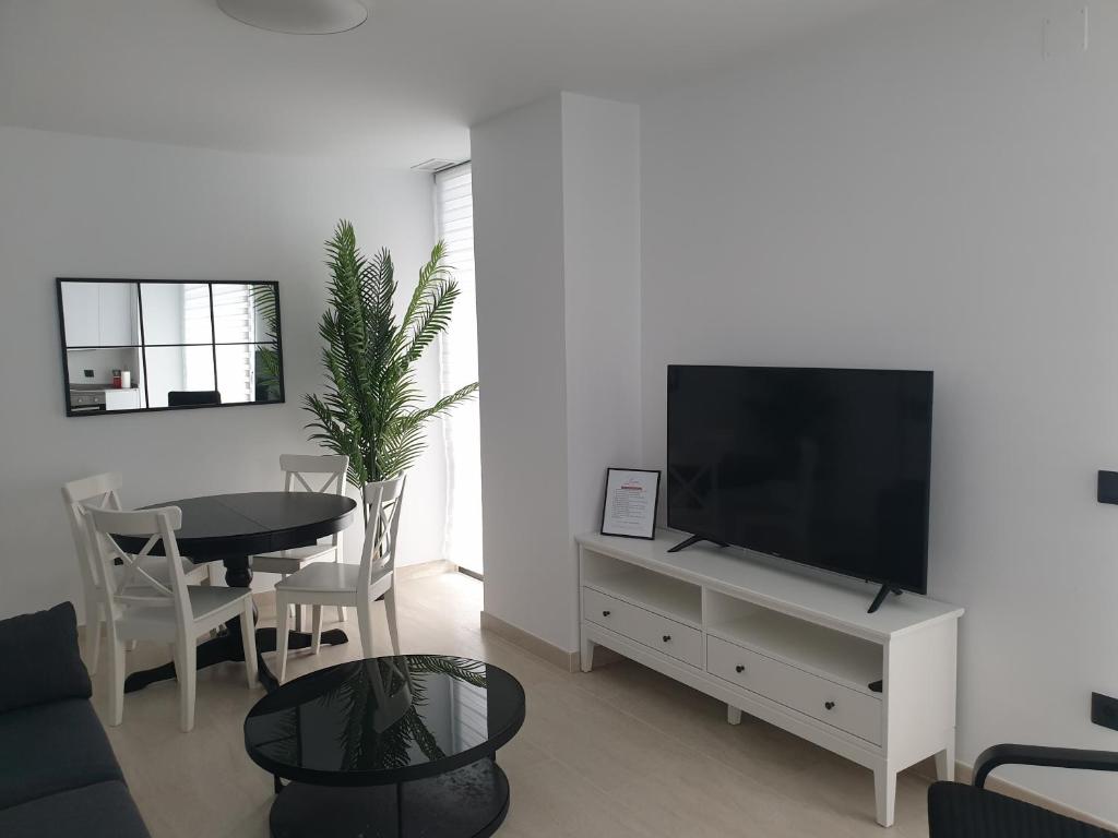 a living room with a flat screen tv and a table at LHOME CÁDIZ in Cádiz