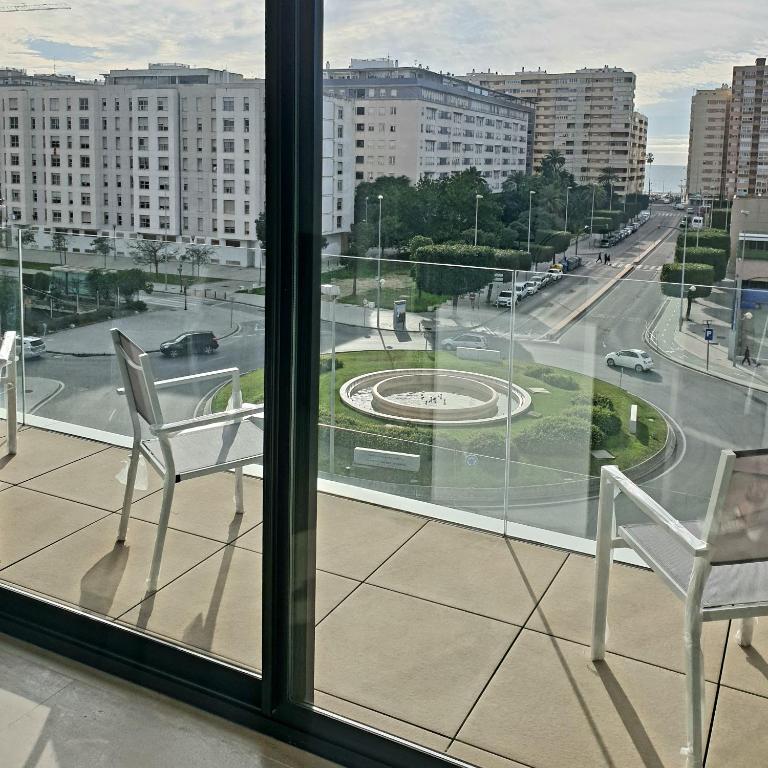 two chairs sitting on a balcony with a view of a city at LHOME CÁDIZ in Cádiz