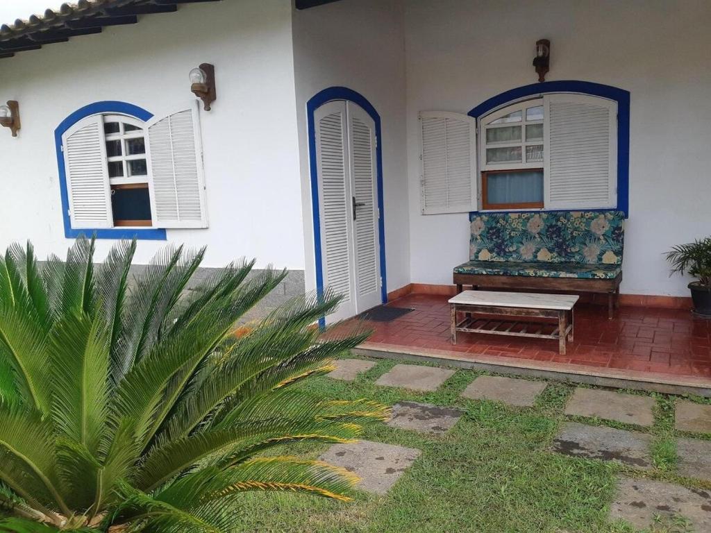 Un porche de una casa con un banco y dos ventanas. en Cabo Frio, a melhor temporada, com menor preço., en Cabo Frío
