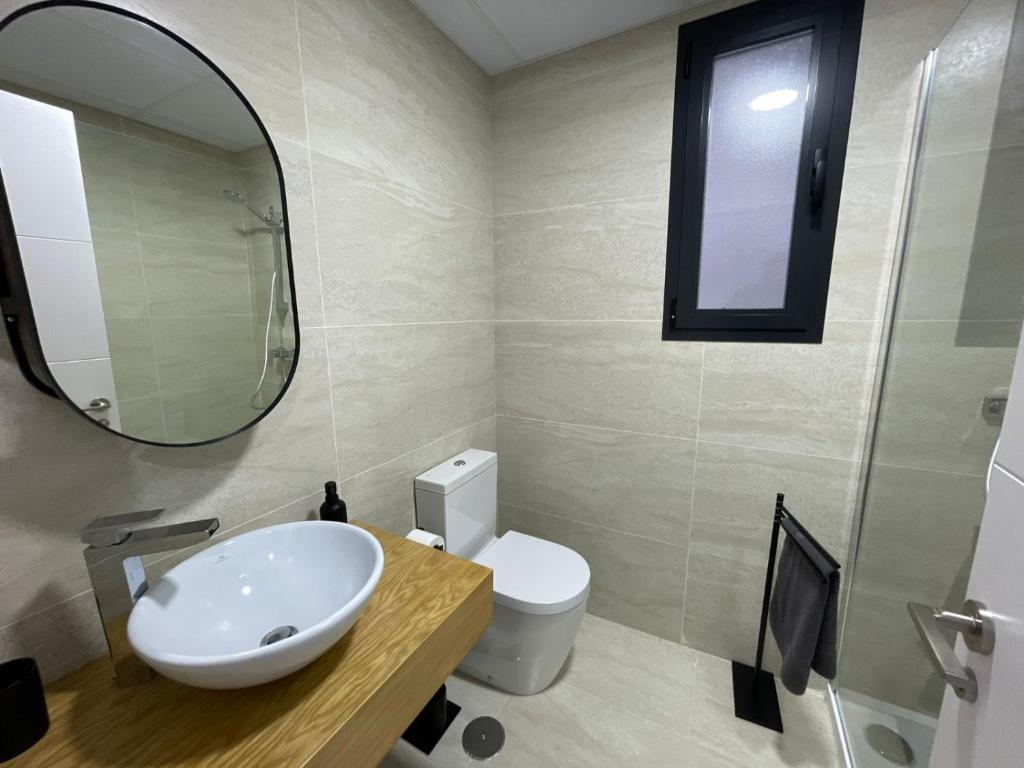 a bathroom with a sink and a mirror and a toilet at LHOME CÁDIZ in Cádiz