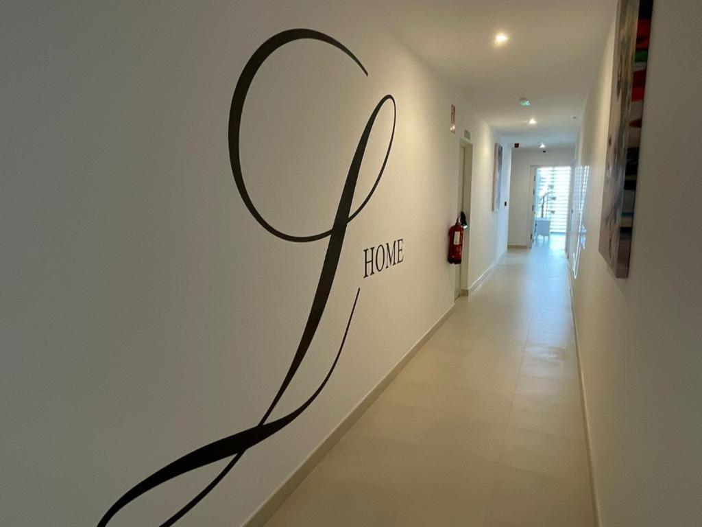 a hallway with a sign that says home on the wall at LHOME CÁDIZ in Cádiz