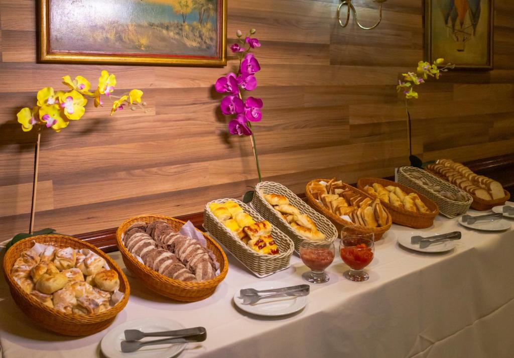 a table with baskets of bread and pastries on it at Rio Aeroporto Hotel Galeão in Rio de Janeiro
