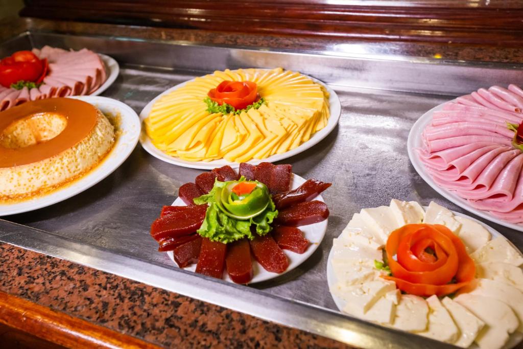 a bunch of different types of cakes on plates at Rio Aeroporto Hotel Galeão in Rio de Janeiro
