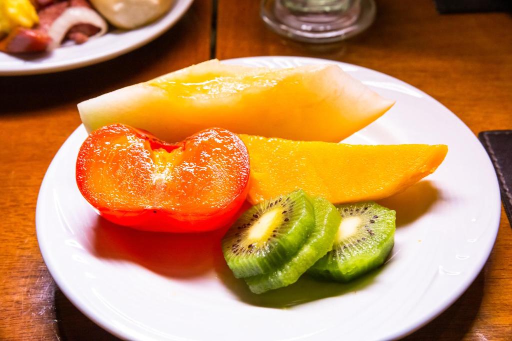 a plate of fruit and vegetables on a table at Rio Aeroporto Hotel Galeão in Rio de Janeiro