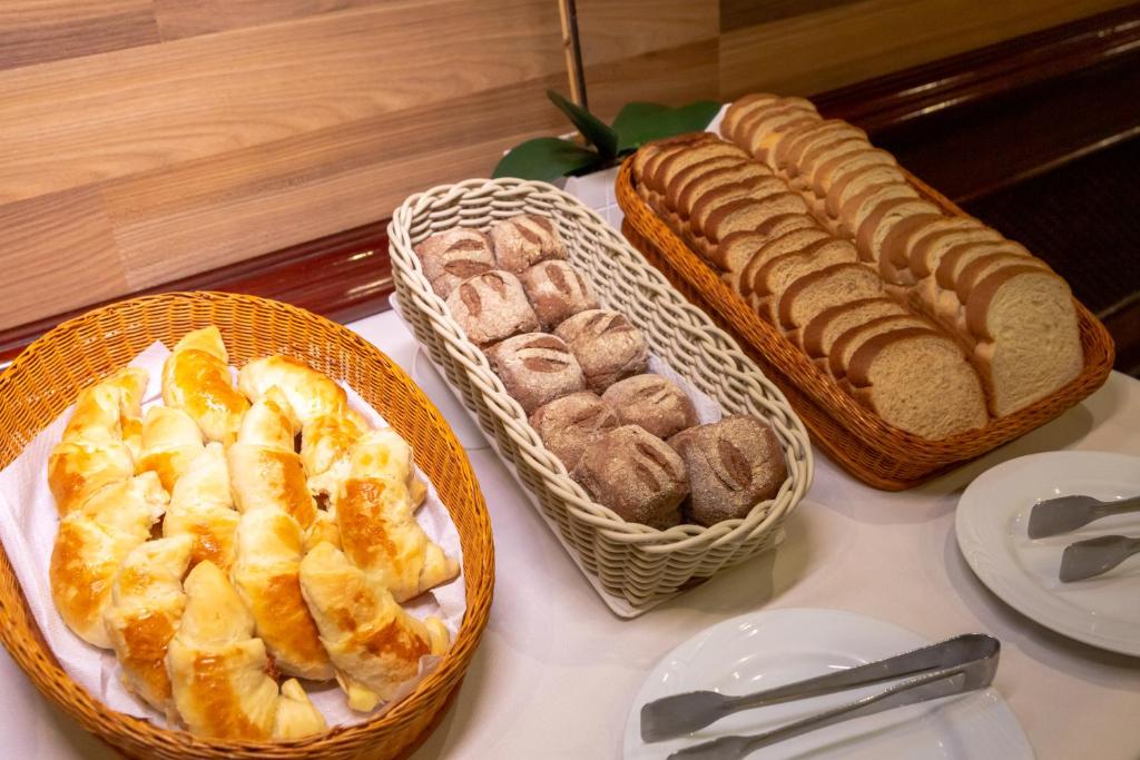 a table topped with baskets of bread and pastries at Rio Aeroporto Hotel Galeão in Rio de Janeiro