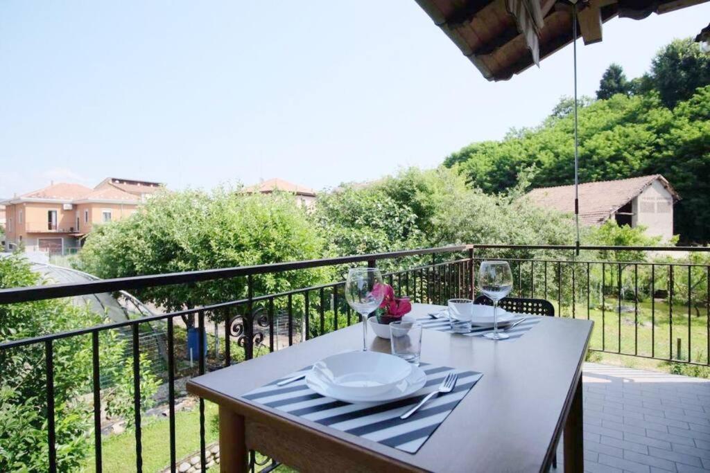 a white table with wine glasses on a balcony at Il Vecchio Kiwi - House with private garden in Oleggio Castello