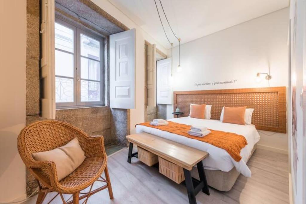 um quarto com uma cama grande e uma cadeira em GuestReady - Genuine Oporto Apts - 4 no Porto
