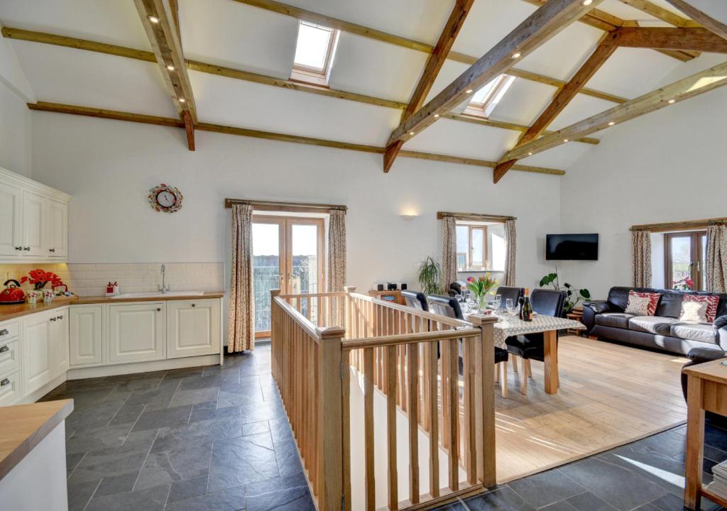 a large living room with a kitchen and a table at The Granary Muddiford in Shirwell
