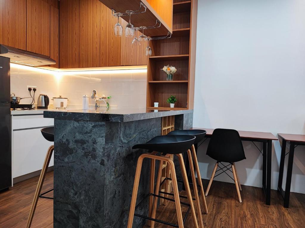 a kitchen with a counter and bar stools at Family-Friendly 2BR Apartment , Cozy Room near MITEC Malaysia , Arte Mont Kiara in Kuala Lumpur