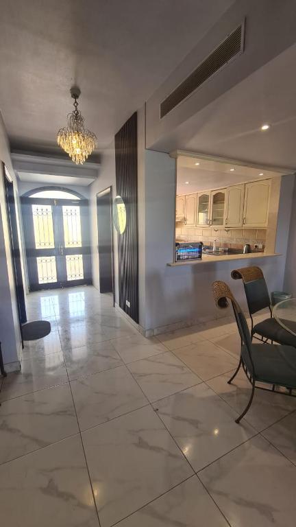 a living room with a chandelier and a table and chairs at درة العروس كورال بيتش فيلا in Durat Alarous