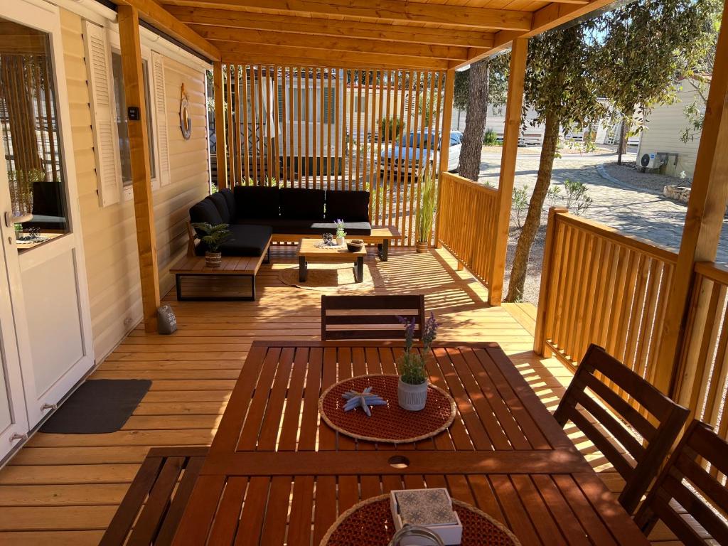 a patio with a couch and a table on a deck at Happy Home in Biograd na Moru