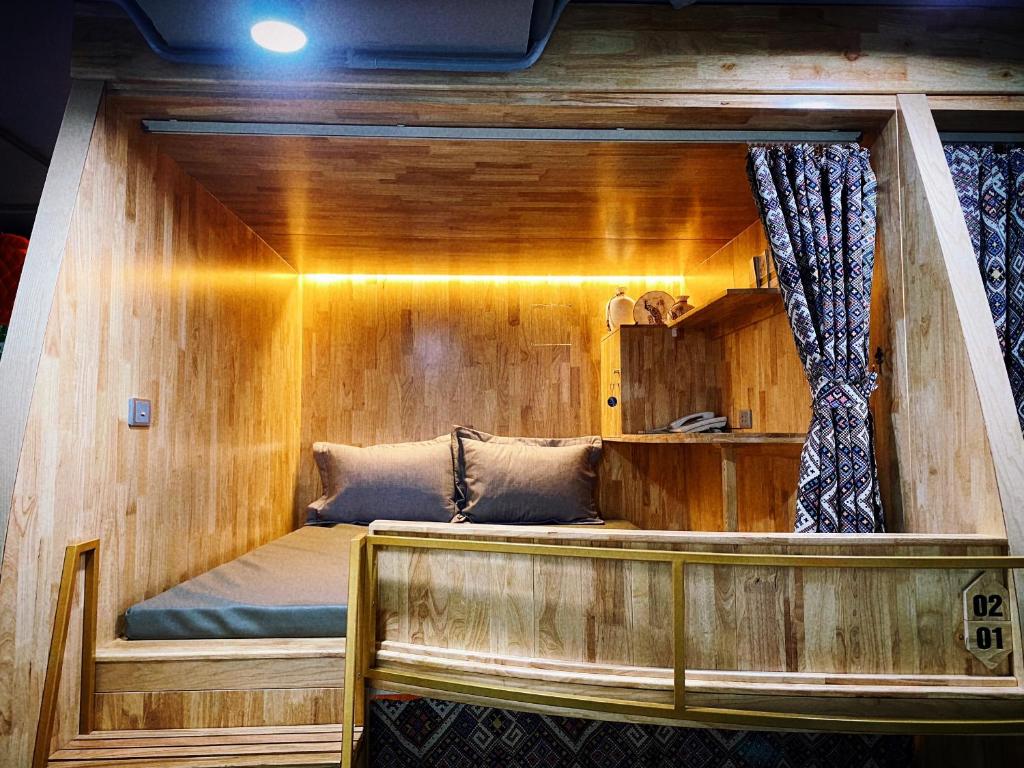 Cama en habitación con pared de madera en Sky Homestay Ha Giang, en Ha Giang