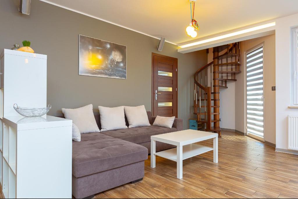 salon z kanapą i stołem w obiekcie Apartament Baltic C21 w mieście Darłowo