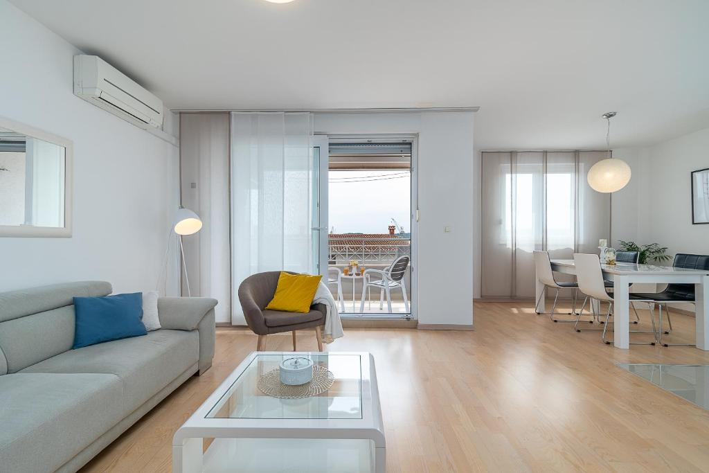 een woonkamer met een bank en een tafel bij Apartman Marino in Trogir