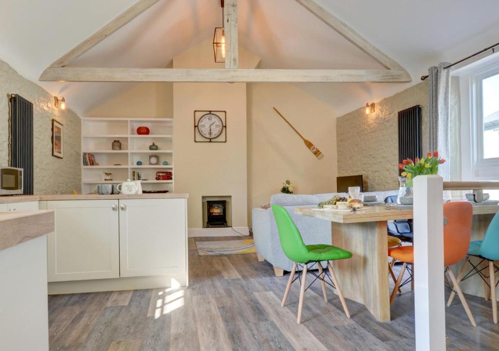 a kitchen and living room with a table and chairs at Hideaway in Appledore