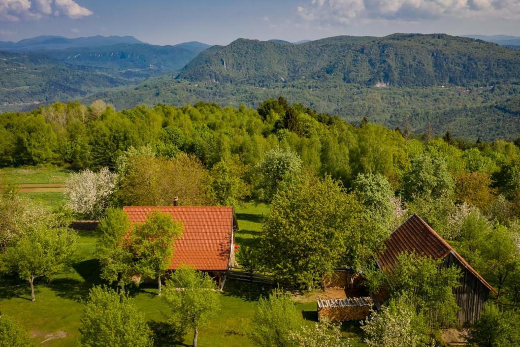 a barn in a field with trees and mountains at Holiday house with a parking space Sleme Skradsko, Gorski kotar - 20726 in Skrad