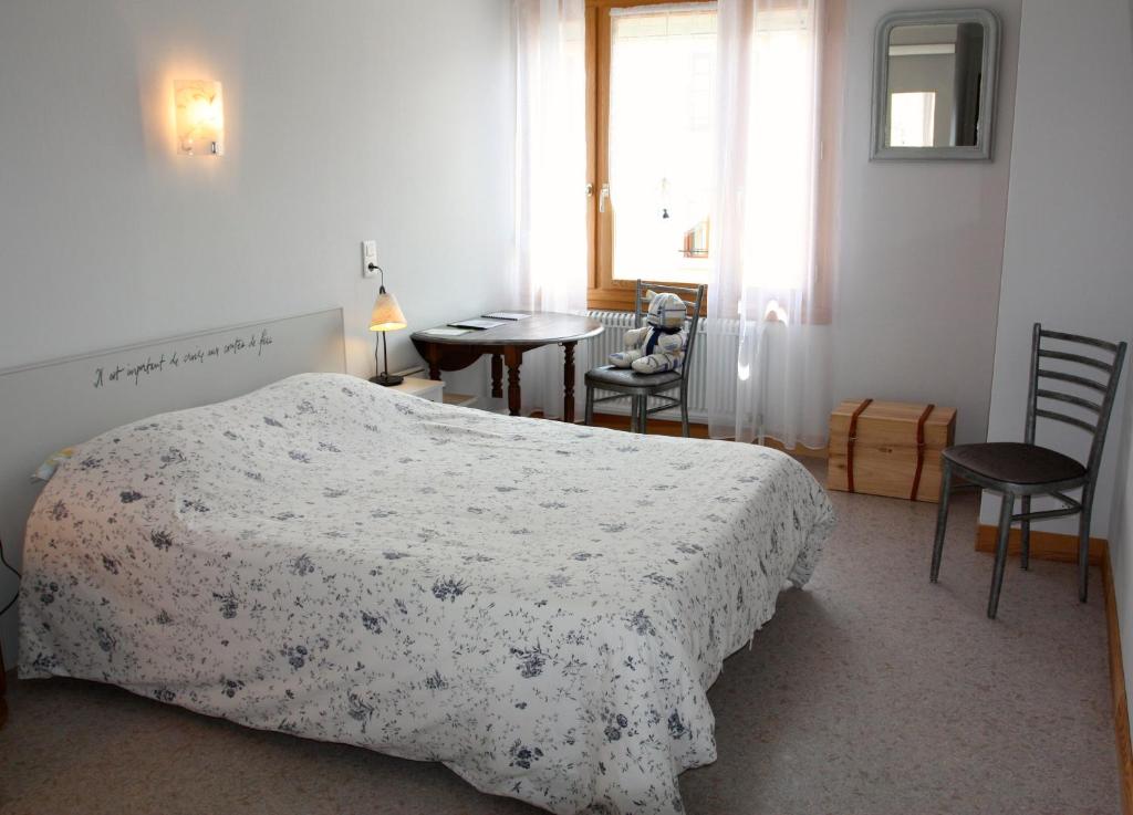 1 dormitorio con 1 cama, mesa y sillas en Le Relais du Coustoubi, en Campouriez