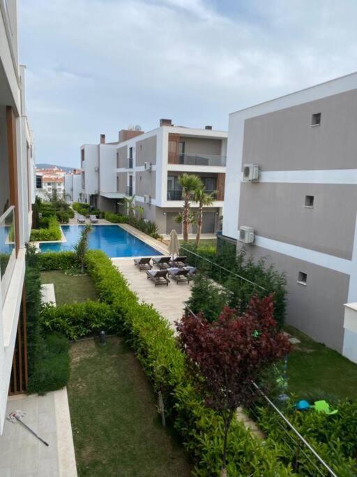 an apartment yard with a swimming pool in a building at Daire in Çeşme