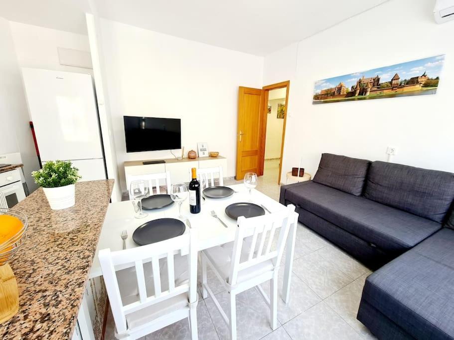 a living room with a white table and a couch at Comfy Apartment With a Castle View in Cullera