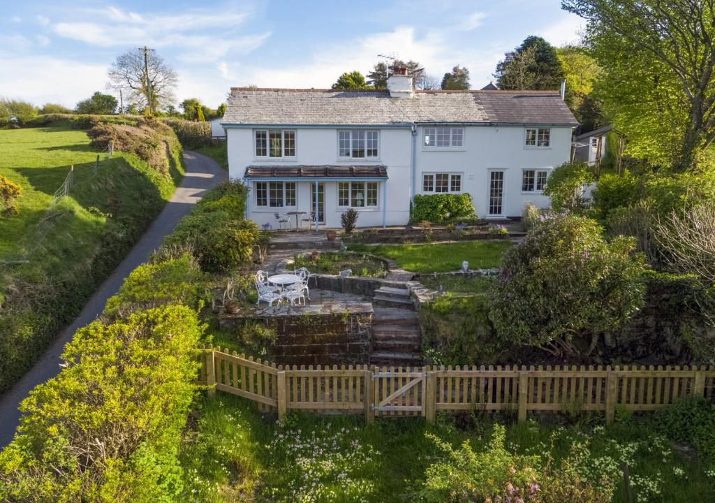 an aerial view of a white house with a wooden fence at Keepers Cottage Lynton in Barbrook